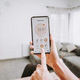 Controlling home heating temperature with a smart home, close-up on phone. Concept of a smart home and mobile application for managing smart devices at home